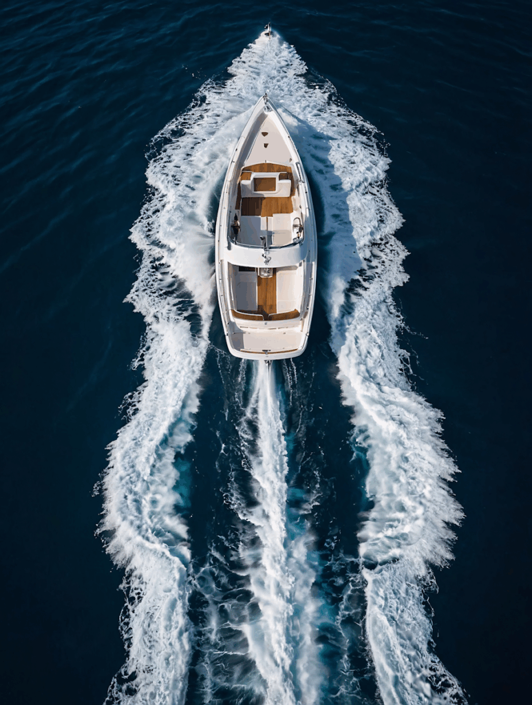 Aerial view of a luxurious white motorboat cruising through deep blue waters